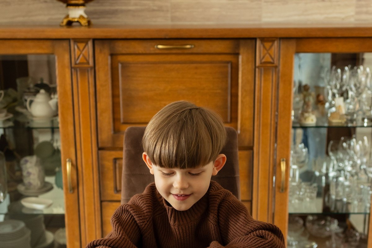 A young child placing tiles in a wooden picture-matching game at a table