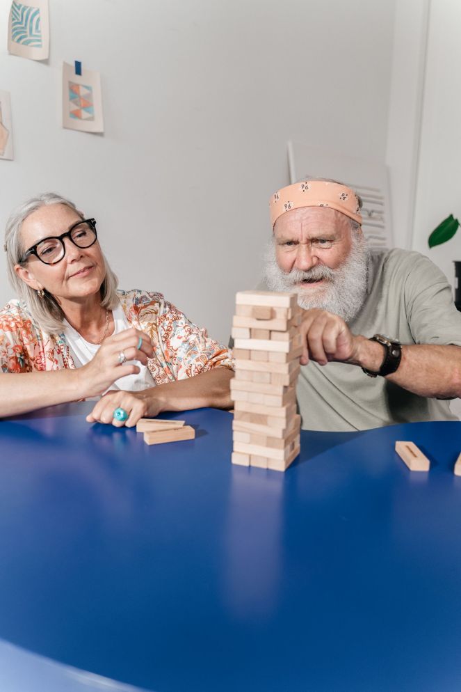 An older couple playing Jenga together at a table