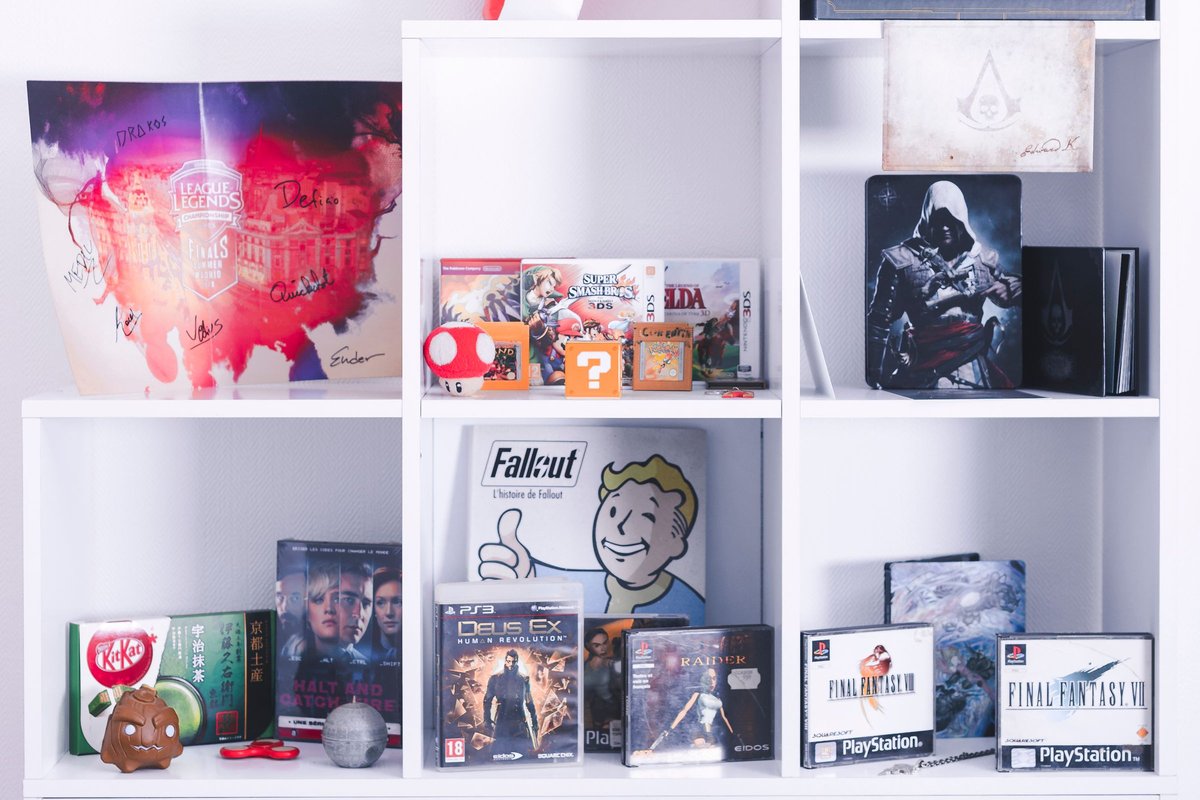Board game and media boxes arranged on a white shelf