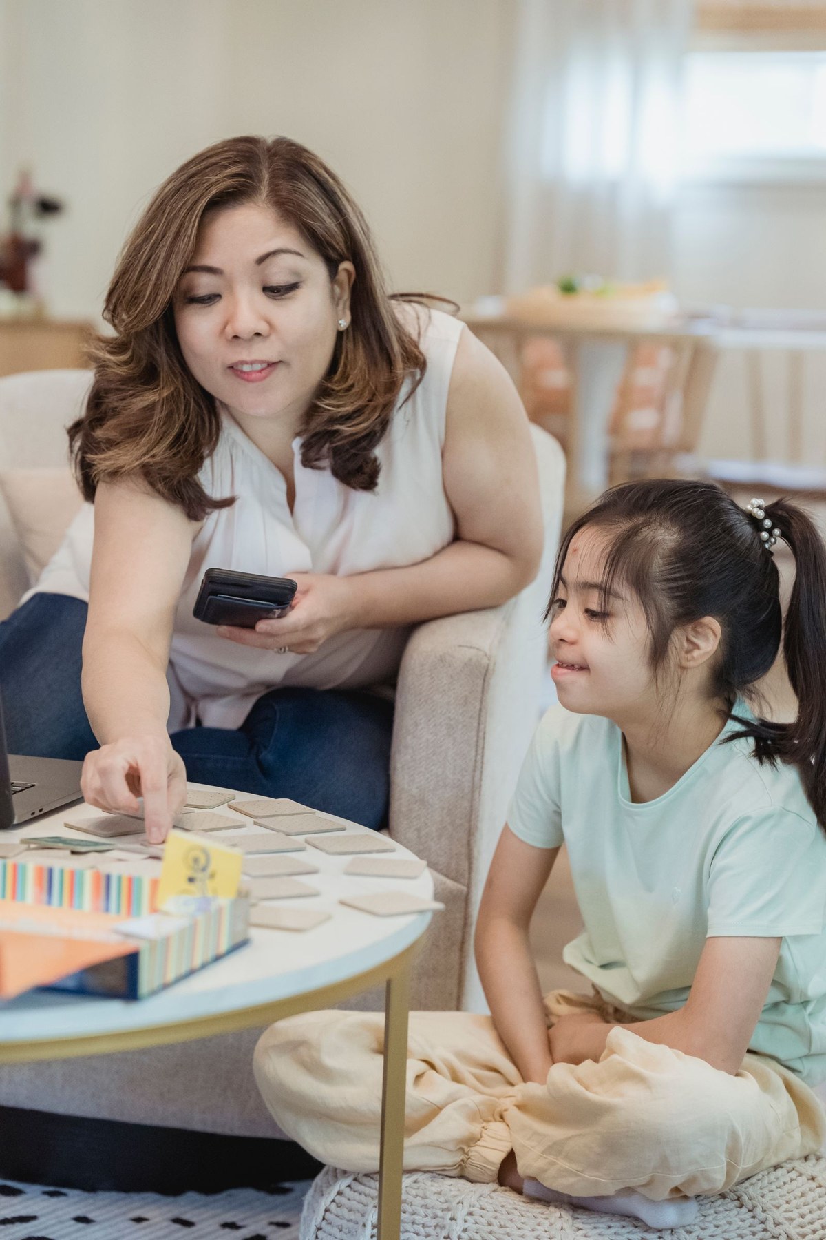 A mother and daughter playing a tile-matching game together in their living room