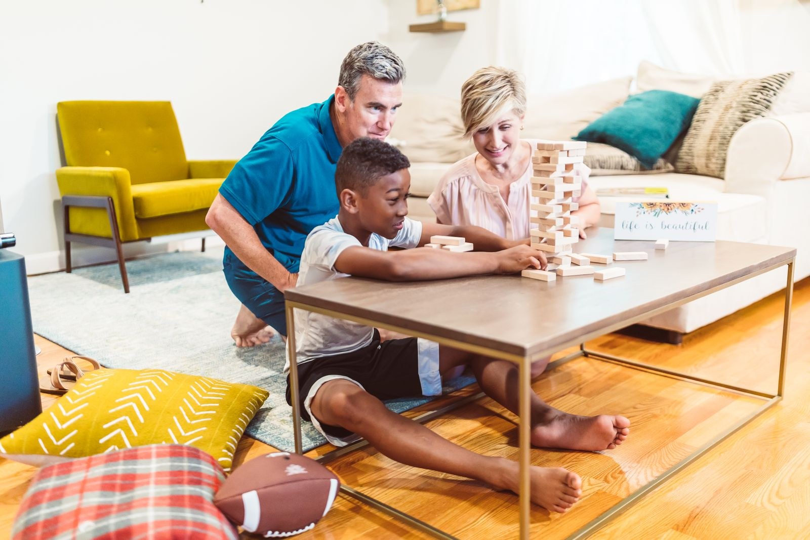 Grandparents playing a stacking block game with their grandson at home
