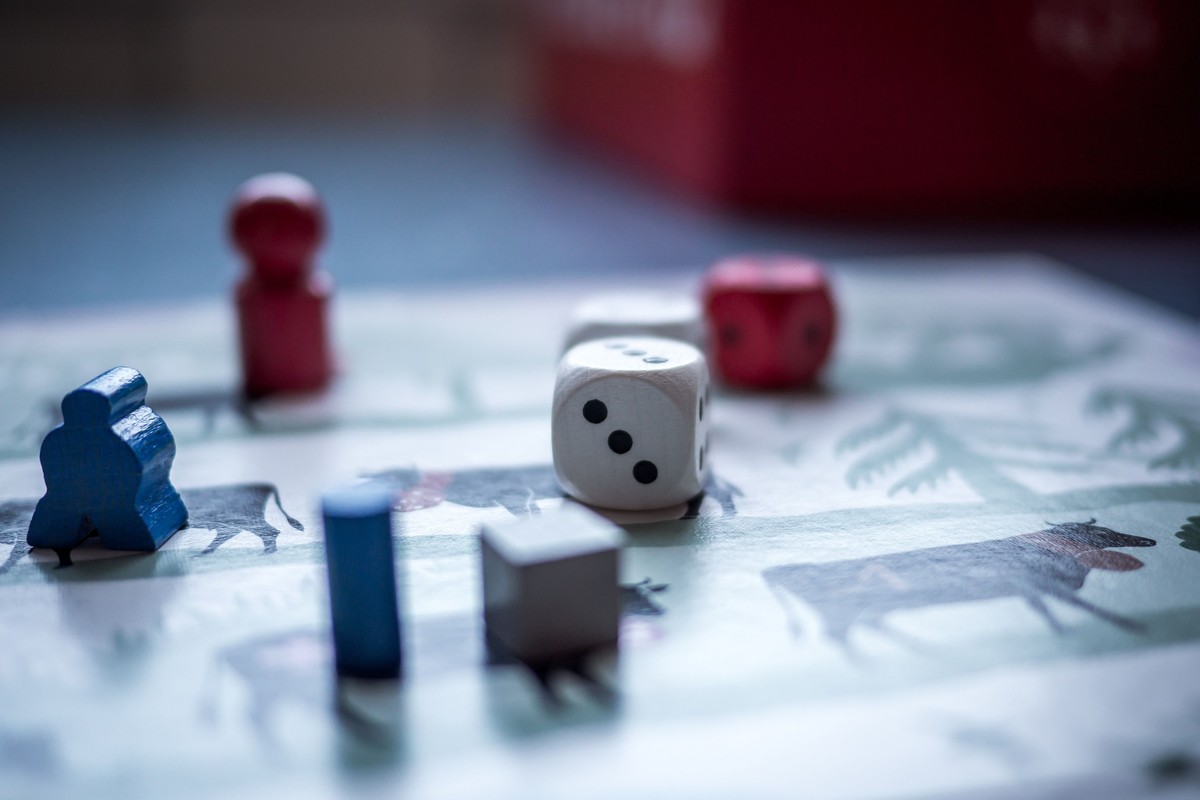 Wooden pawns, dice and a board close up on a table